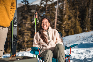 woman-sitting-on-snowy-mountain-with-family