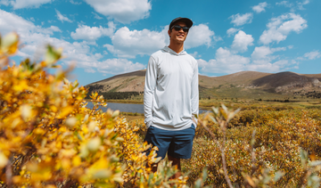 Man wearing a Vapor Apparel fall outfit standing in a field in fall