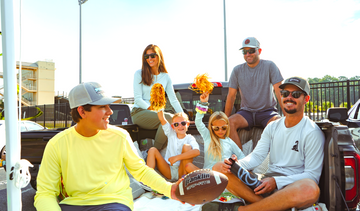 People tailgating for college football game in sun protection gear